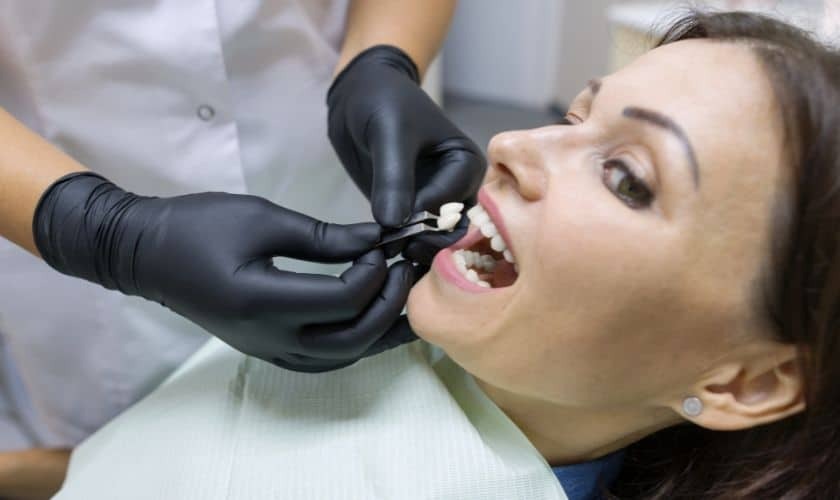 Dentist examining patient's teeth during cosmetic dental treatment in Saginaw.