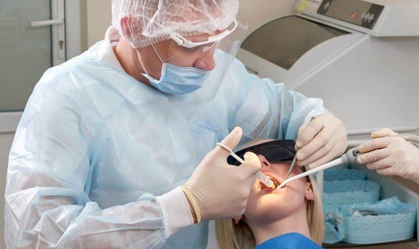 Dentist performing oral surgery procedure on patient in Saginaw dental office.