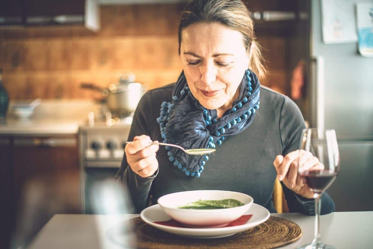 Woman enjoying soft soup after root canal treatment in Saginaw.